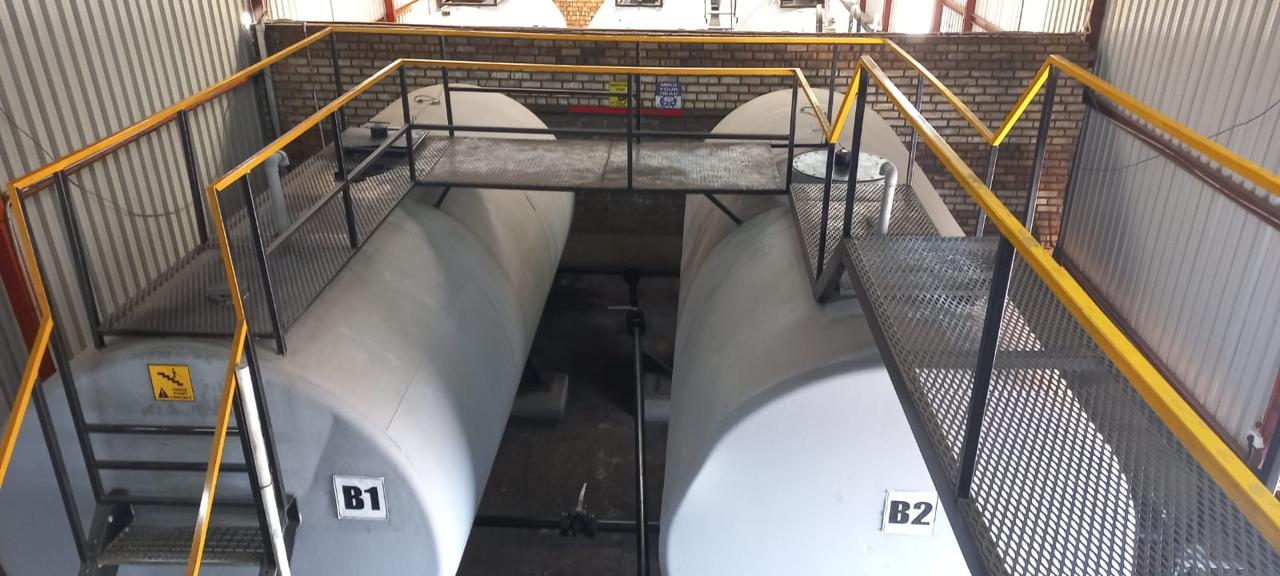Large white bulk fuel storage tanks marked B1 and B2